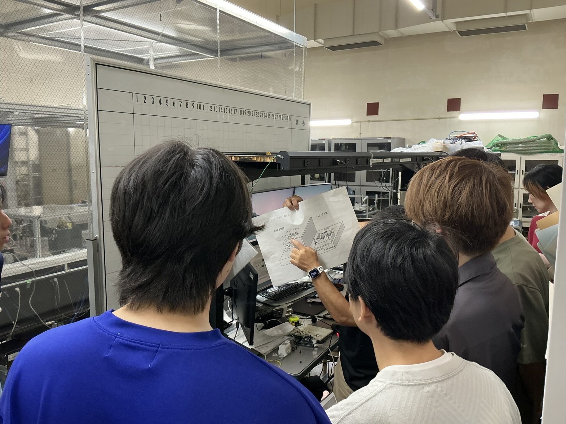 研究設備について説明を受ける学生