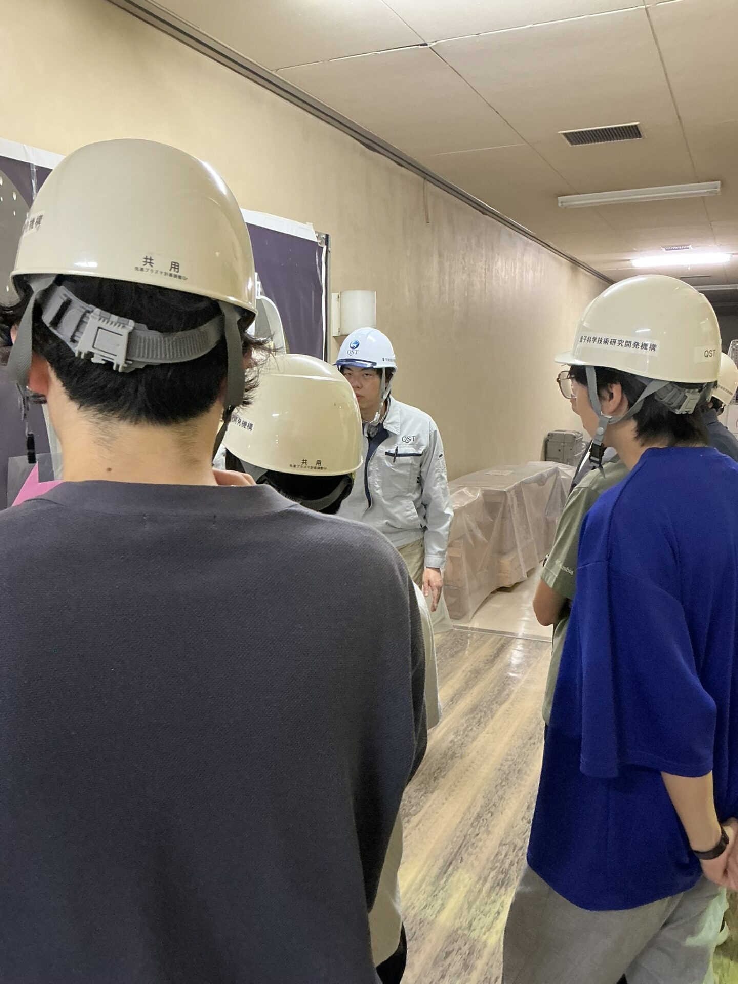 QST職員から研究施設の説明を受ける学生